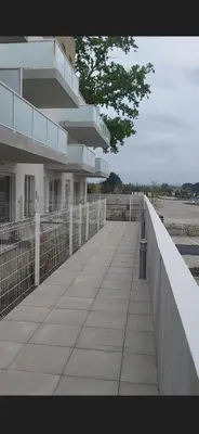 a walkway in front of a building with a fence at Appartement avec balcon/terrasse in Monteux