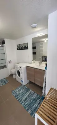 a bathroom with a sink and a washing machine at Appartement avec balcon/terrasse in Monteux
