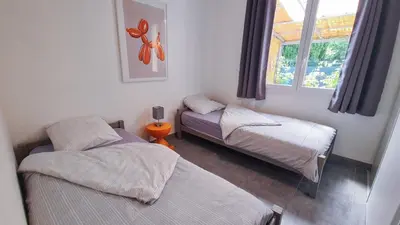 a room with two beds and a window at Jolie villa loc-saisonnière - la petite cocagne in Alleins