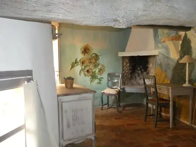 a living room with a table and a fireplace at Le Jas des aiguiers in Saint-Saturnin-les-Apt