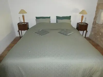 a large bed in a bedroom with two night stands at Le Jas des aiguiers in Saint-Saturnin-les-Apt
