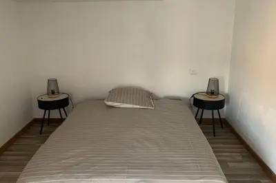 a bed in a room with two side tables at Duplex à Monteux centre, 5 couchages distincts, LOCAL VELOS in Monteux