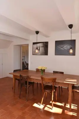 a dining room with a wooden table and chairs at L'Atelier Appartement au cœur du vignoble in Rognes