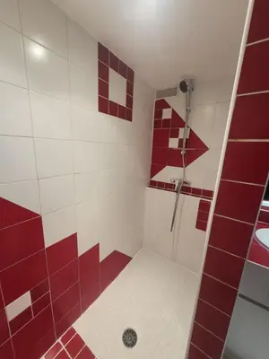 a bathroom with red and white tiles and a shower at Appartement au Cœur de la Sorgue in LʼIsle-sur-la-Sorgue