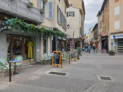 a street with chairs and tables and a store at Appartement au Cœur de la Sorgue in LʼIsle-sur-la-Sorgue