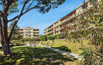 an apartment building with trees in front of a building at Nice Apartment In Carpentras With Wifi in Carpentras