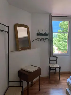 a bedroom with a mirror and a chair and a table at Bergerie Joy, bienvenue entre Ciel & Terre in Saint-Christol