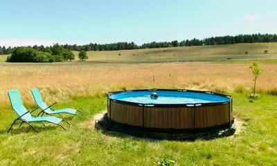 a couple of chairs and a pool in a field at Bergerie Joy, bienvenue entre Ciel & Terre in Saint-Christol