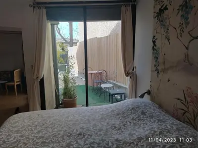 a bedroom with a bed and a view of a garden at la maison de josy in Aix-en-Provence