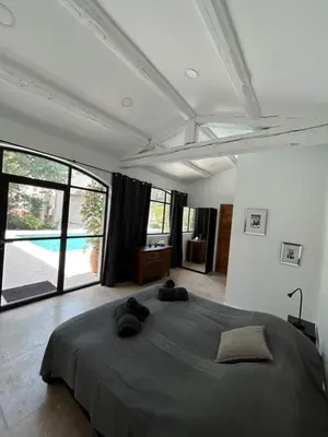 a bedroom with a large bed and a large window at La Bastide des Rosiers in Mallemort
