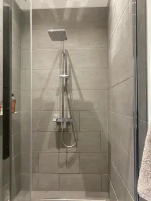 a shower with a glass door in a bathroom at La Bastide des Rosiers in Mallemort