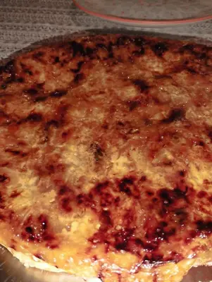 a close up of a pizza with cheese and sauce at Chambre d hôtes en Provence, au pied du Luberon, les Coquelicots in La Tour-dʼAigues