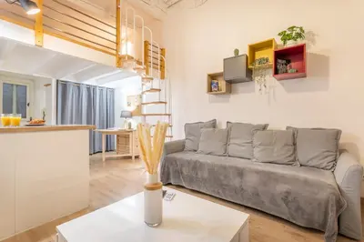 a living room with a couch and a kitchen at Studio Cardeurs in Aix-en-Provence