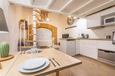 a kitchen with a wooden table with plates on it at Studio Cardeurs in Aix-en-Provence