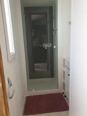 a bathroom with a shower with a glass door at Camping Domaine des Iscles in La Roque-dʼAnthéron