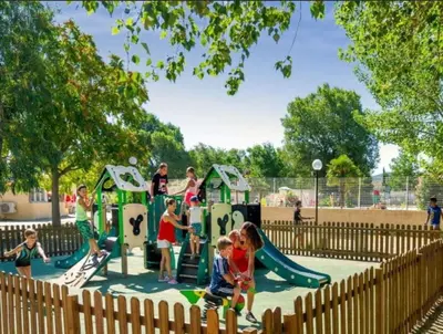 a group of children playing in a playground at Camping Domaine des Iscles in La Roque-dʼAnthéron