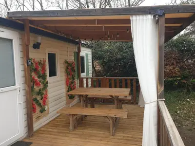 a wooden picnic table on a wooden deck at Camping Domaine des Iscles in La Roque-dʼAnthéron