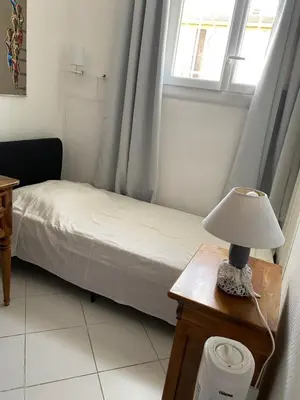 a small bedroom with a bed and a lamp on a table at VILLA MIREILLE CALME ARBOREE PISCINE SANS VIS A VIS SECURISEE in Morières-lès-Avignon