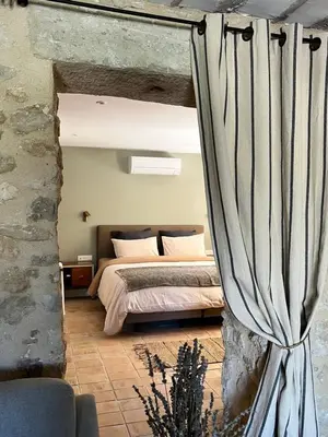 a bedroom with a bed and a curtain at Mas Saint-Genies in Venasque