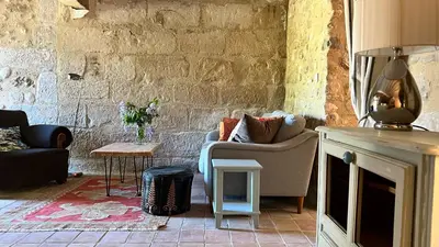 a living room with a couch and a fireplace at Mas Saint-Genies in Venasque