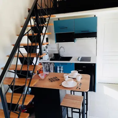 a kitchen with blue cabinets and a table with chairs at Le Cabanon des Lavandes entre Mont Ventoux et Luberon in Sault-de-Vaucluse