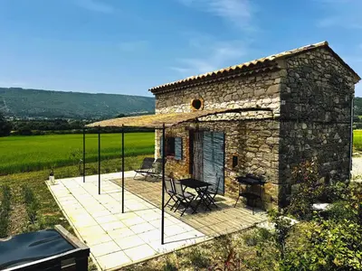 a small stone house with a patio and a view at Le Cabanon des Lavandes entre Mont Ventoux et Luberon in Sault-de-Vaucluse