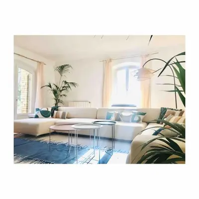 a living room with a white couch and tables at Villa des Baumes in Cornillon-Confoux