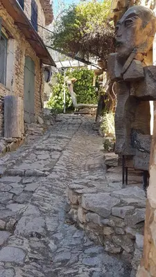 a stone path in front of a building with a statue at Magic views in paradise in Joucas
