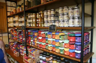 a store shelf filled with lots of canned food at Gîte Les Hauts Sauviers avec piscine et sauna in Bédoin