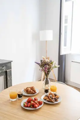 three plates of food on a table with orange juice at Studio Mezzanine Aumône Vieille in Aix-en-Provence