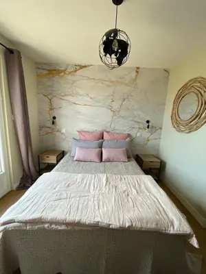 a bedroom with a large bed with pink pillows at Chambre d'hôtes avec Jacuzzi Ventoux Cocoon in Bédoin