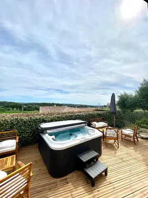 a hot tub sitting on top of a wooden deck at Chambre d'hôtes avec Jacuzzi Ventoux Cocoon in Bédoin