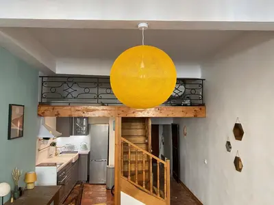 a large yellow orb hanging from the ceiling of a kitchen at Studio Mezzanine Mairie in Aix-en-Provence