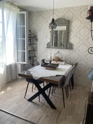 a dining room with a table with chairs and a mirror at Appartement avec jardin en ville in LʼIsle-sur-la-Sorgue