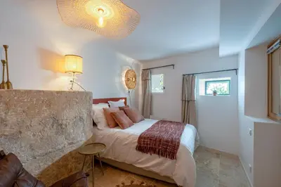 a bedroom with a large bed with pink pillows at La Grange de la Chèvre d'Or in Lagnes