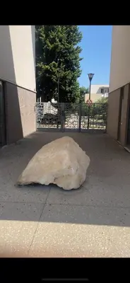 a large rock sitting on the sidewalk next to a building at Appartement Studio en résidence Avignon zone Agroparc in Avignon