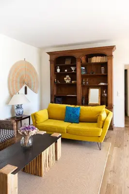 a living room with a yellow couch and a table at La case d'Eyragues, au coeur des Alpilles in Eyragues
