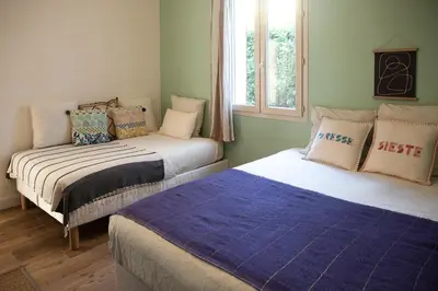 two beds sitting in a room with a window at La case d'Eyragues, au coeur des Alpilles in Eyragues