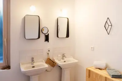 a bathroom with a sink and two mirrors on the wall at La case d'Eyragues, au coeur des Alpilles in Eyragues