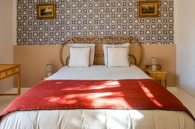 a bedroom with a bed with a red blanket at La case d'Eyragues, au coeur des Alpilles in Eyragues