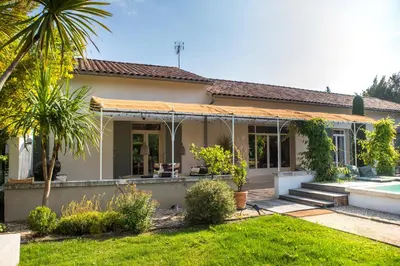 a house with a porch and a palm tree at La case d'Eyragues, au coeur des Alpilles in Eyragues