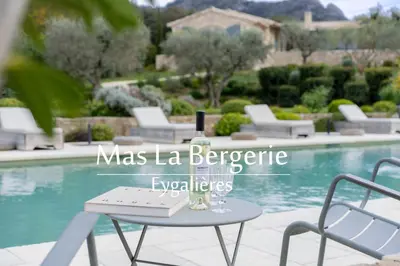 a table and chairs next to a swimming pool at Mas La Bergerie in Eygalières