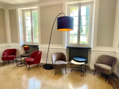 a room with chairs and a table and a lamp at La Pavoyère in Mormoiron