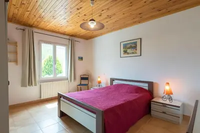 a bedroom with a large bed with a purple blanket at Le Mas du Miel d'Or, 12 pers, au coeur du Luberon, air-conditionné, piscine, propriété de 5000 m2 in Villars