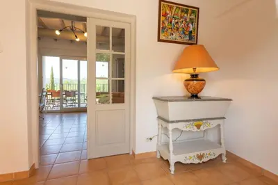 a lamp on a white table in a hallway at Le Mas du Miel d'Or, 12 pers, au coeur du Luberon, air-conditionné, piscine, propriété de 5000 m2 in Villars