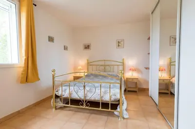 a bedroom with a bed and two tables with lamps at Le Mas du Miel d'Or, 12 pers, au coeur du Luberon, air-conditionné, piscine, propriété de 5000 m2 in Villars
