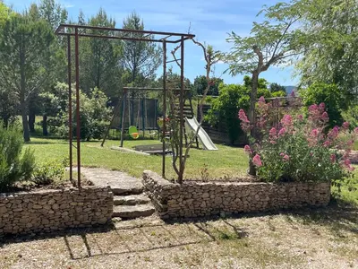 a park with a playground and a swing at Le Mas du Miel d'Or, 12 pers, au coeur du Luberon, air-conditionné, piscine, propriété de 5000 m2 in Villars