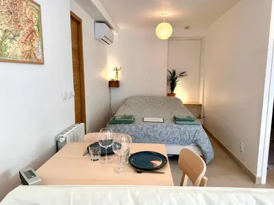 a room with a bed and a table with glasses on it at Paisible studio tout neuf en lisière de forêt in Peyrolles-en-Provence