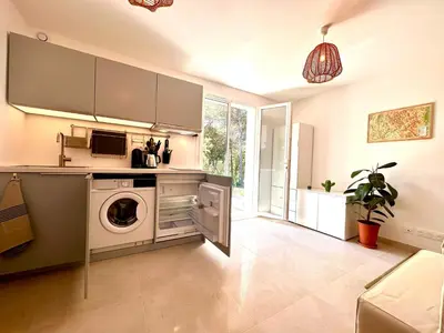 a kitchen with a washer and dryer in a room at Paisible studio tout neuf en lisière de forêt in Peyrolles-en-Provence