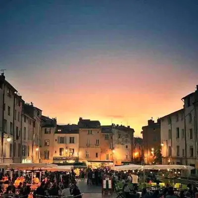a crowd of people walking around a city at sunset at Au cœur d’Aix-en-Provence in Aix-en-Provence